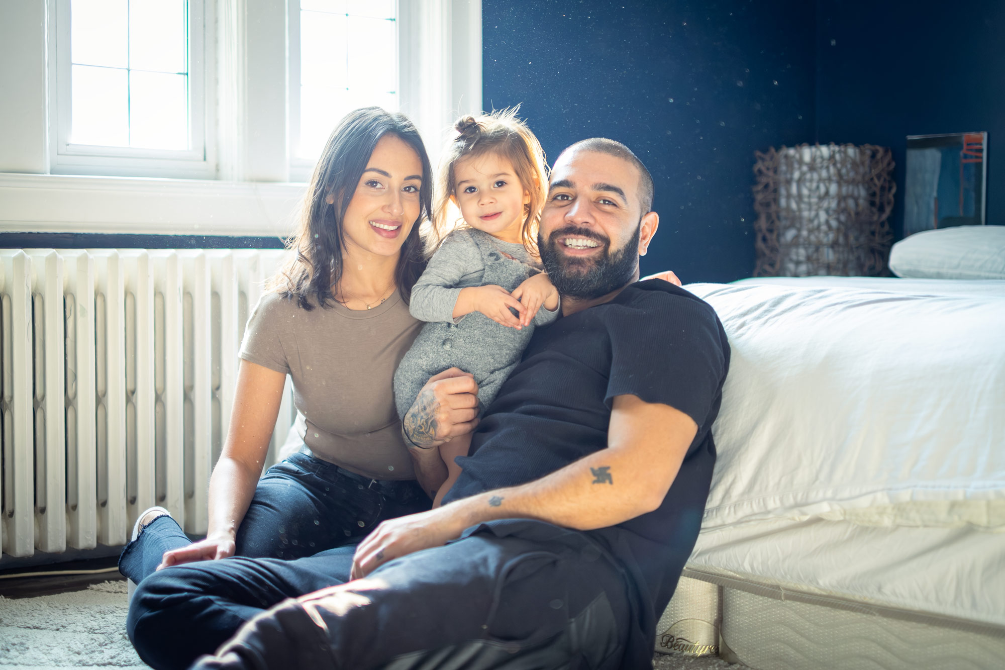 Mom and dad laughing with their toddler during a relaxed in-home family photography session